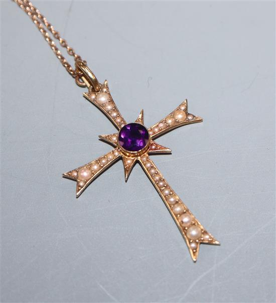 An Edwardian 15ct gold, amethyst and seed pearl set cross pendant, on a yellow metal fine link chain, pendant 36mm.